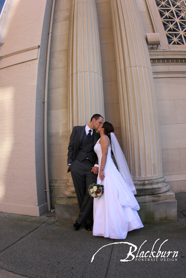 Franklin Plaza Wedding Photo Bride and Groom kissing next to columns outside of Franklin Plaza in Troy